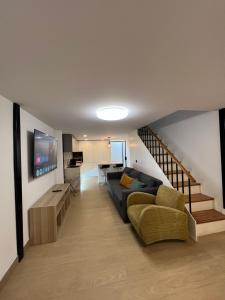 a living room with a couch and a staircase at Serena Boutique Duplex in Madrid