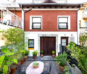 a courtyard of a house with plants and a table at La Fuente 33 in Castro-Urdiales
