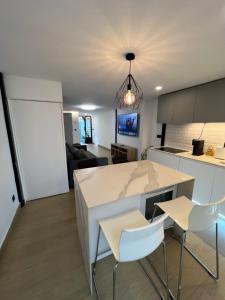 a kitchen and living room with a counter and chairs at Serena Boutique Duplex in Madrid +10 photos