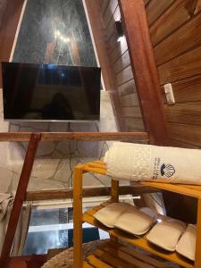 a tv and a table with a pillow on a shelf at Pérola Cabana in Serra de São Bento