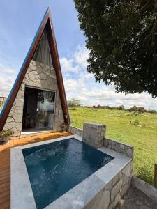 a small swimming pool with a stone house at Pérola Cabana in Serra de São Bento