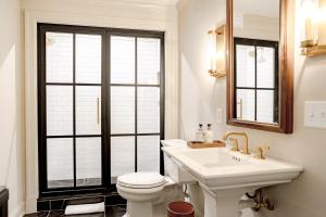 a white bathroom with a sink and a toilet at Hotel Burg in Leesburg