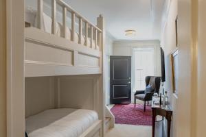 a bedroom with a bunk bed and a chair at Hotel Burg in Leesburg