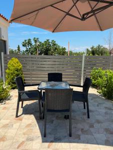 a table and chairs under an umbrella on a patio at Calliopi's studio in Plytra