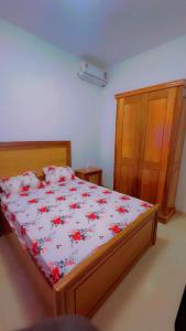 a bedroom with a bed with red flowers on it at Kaila 1 in Keur Massar