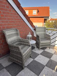 two wicker chairs and a table on a patio at Weitblick Neviges in Velbert