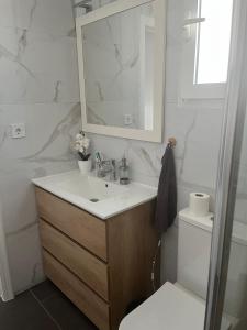 a bathroom with a sink and a mirror and a toilet at Las Carolinas residence with pool in San Miguel de Salinas +14 photos