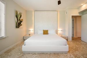 a white bedroom with a large bed and two tables at Cardozo Hotel in Miami Beach +93 photos