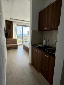 a kitchen with a sink and a living room at Apartments Komina in Utjeha