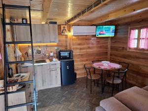 a kitchen and dining room with a table in a cabin at Brvnara Mia in Rudnik