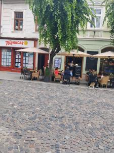 a cobblestone street with people sitting outside a restaurant at Apartmán pod hradom B in Trenčín