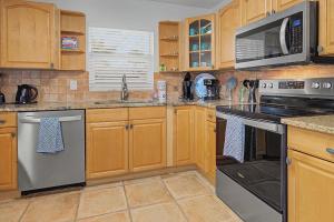 a kitchen with wooden cabinets and stainless steel appliances at Manatee Bay in Apollo Beach