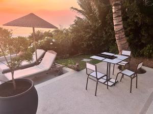 a patio with a table and chairs and an umbrella at Bed and breakfast ALDIANA in Cap Skirring