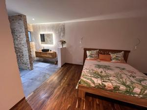 a bedroom with a bed and a bathroom with a sink at Bed and breakfast ALDIANA in Cap Skirring