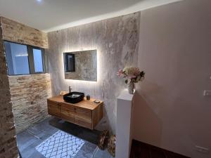 a bathroom with a sink and a vase of flowers at Bed and breakfast ALDIANA in Cap Skirring