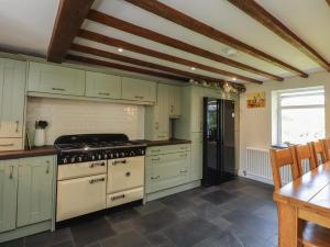a kitchen with white cabinets and a stove top oven at Plas Mawr in Caernarfon
