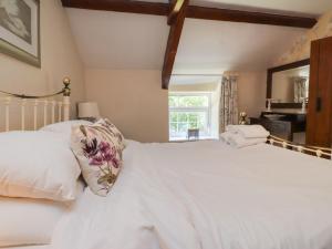 a bedroom with a large white bed and a window at Plas Mawr in Caernarfon