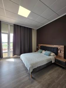a bedroom with a large bed and a large window at Hotel La Oficina in San Miguel de Salinas