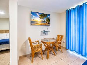 a dining room with a table and chairs and a bed at Golden Villas 306B studio in Isabela