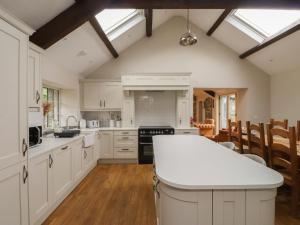 a kitchen with white cabinets and a white counter top at Beudy'r Wennol in Caernarfon