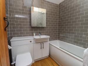 a bathroom with a sink and a tub and a toilet at Beudy'r Wennol in Caernarfon +28 photos