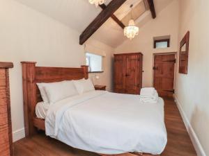 a bedroom with a large white bed in a room at Beudy'r Wennol in Caernarfon