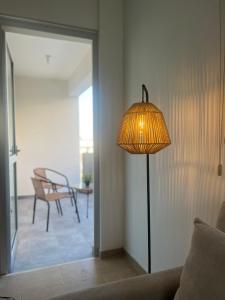 a lamp in a living room with a table and a chair at Melissa 2 Block A in Paralimni
