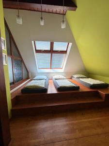 three beds in a room with a window at RAST apartment house in Třebíč