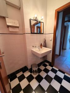 a bathroom with a sink and a mirror and a checkered floor at RAST apartment house in Třebíč +21 photos