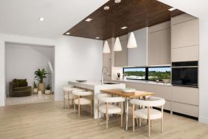 a kitchen with a wooden table and white cabinets at Villa Angelina in Leeward