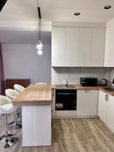 a kitchen with white cabinets and a wooden counter top at Your Cozy Home 2BR Local Vibe 25 Mins to Center in Yerevan