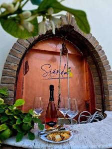 a table with a bottle of wine and glasses at Sienda Cesira in Muravera +31 photos