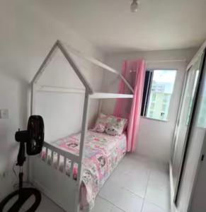 a small bedroom with a bed with pink curtains at Apto no Janga in Paulista