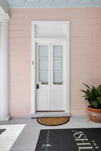 a white door on a pink house with a welcome mat at The Ashley Speakeasy King Suite includes breakfast in Charleston