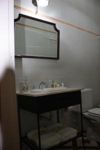 bagno con lavandino, specchio e servizi igienici di Carmine Hotel Apart a Capilla del Señor