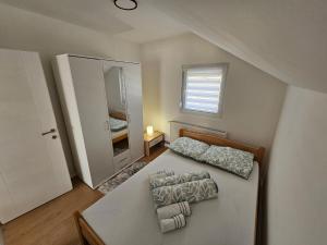 a small bedroom with a bed and a mirror at Airport Apartment II in Surčin