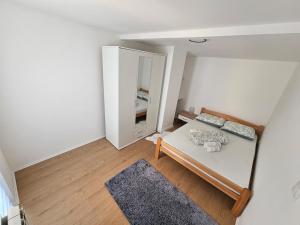 a small white room with a bed and a mirror at Airport Apartment II in Surčin