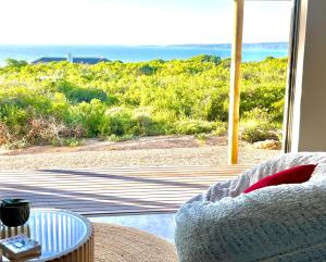 a living room with a view of the ocean at Wild Comforts at Springerbaai in Boggomsbaai