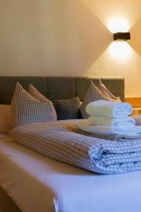 a pile of towels sitting on top of a bed at Landhaus No 12 mit privater Sauna in Bayrischzell