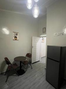 a room with a table and chairs and a refrigerator at Aviela Residences in Solwezi