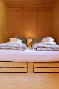 two beds in a room with wooden walls at Landhaus No 12 mit privater Sauna in Bayrischzell +38 photos