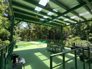 a green pergola with chairs and tables on a patio at Cocles Green Studios in Cocles