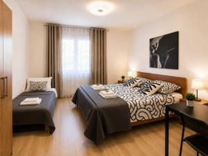a bedroom with a bed and a table and a desk at Appartamento Orchidea in Monfalcone