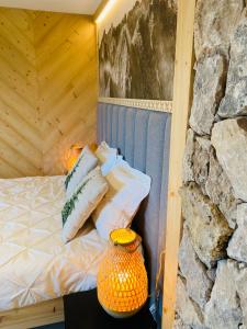 a bed with pillows on it next to a stone wall at Orla Przystań in Gliczarów Górny