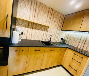 a kitchen with a sink and wooden cabinets at Orla Przystań in Gliczarów Górny