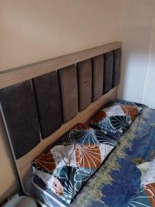 a bed with a brown headboard and two pillows at شقة 24 in Irbid