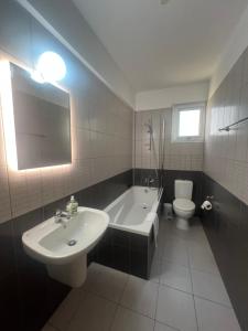 a bathroom with a sink and a tub and a toilet at Melissa 2 Block A in Paralimni