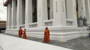 three monks in orange robes walking in front of a building at Fp Monza Railways in Monza
