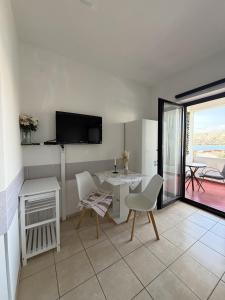 a living room with a table and chairs and a television at Apartments Antonio in Pag