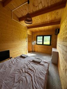 a bedroom with a large bed in a wooden room at Srebrny Domek in Ostroszowice